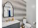 Charming powder room with a unique design, decorative mirror, and a marble countertop at 10353 E Trillium Ave, Mesa, AZ 85212