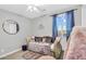 Charming bedroom with a cozy daybed, a round mirror, and soft, natural light from the window at 10353 E Trillium Ave, Mesa, AZ 85212