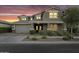 Charming two-story home with gray paint, mature landscaping, and a spacious two-car garage at sunset at 10353 E Trillium Ave, Mesa, AZ 85212