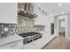 Modern kitchen featuring white cabinets, stainless steel range hood, tile backsplash and wooden flooring at 10353 E Trillium Ave, Mesa, AZ 85212