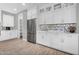 Modern kitchen with white cabinets, stainless steel appliances, tile backsplash and wooden flooring at 10353 E Trillium Ave, Mesa, AZ 85212