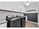 Efficient laundry room with modern washer and dryer, overhead cabinets, and a countertop for folding at 10353 E Trillium Ave, Mesa, AZ 85212