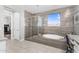 Elegant main bathroom featuring a glass shower, soaking tub, and neutral tile at 10353 E Trillium Ave, Mesa, AZ 85212