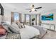 Relaxing main bedroom with a large bed, sitting area, ceiling fan, and a TV on the wall at 10353 E Trillium Ave, Mesa, AZ 85212