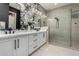 Elegant bathroom featuring dual sinks, stone countertops, framed mirrors and a spacious walk-in shower at 11385 N Luckenbach St, Surprise, AZ 85388
