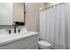 Well-lit bathroom with a modern sink and a shower with white curtain at 11385 N Luckenbach St, Surprise, AZ 85388