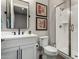 Bathroom with a white vanity, framed art, dark fixtures, and a glass enclosed shower at 11385 N Luckenbach St, Surprise, AZ 85388