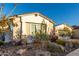 Landscaped yard with flowering plants in front of a light-colored home with a stone-accented facade at 11385 N Luckenbach St, Surprise, AZ 85388