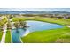Picturesque golf course with a serene lake and lush green landscaping against a mountain skyline at 11385 N Luckenbach St, Surprise, AZ 85388