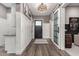 Hallway featuring wood-look flooring, white wainscoting, and modern light fixture at 11385 N Luckenbach St, Surprise, AZ 85388