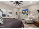 Spacious main bedroom featuring a ceiling fan, sitting area, and large dresser with mounted TV at 11385 N Luckenbach St, Surprise, AZ 85388