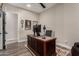Home office featuring a large wooden desk, wood flooring and tennis racket wall art at 11385 N Luckenbach St, Surprise, AZ 85388