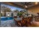Covered patio with dining set, grill, pizza oven, and view of pool and landscaping at 11385 N Luckenbach St, Surprise, AZ 85388
