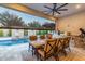 Covered patio with dining set, grill, pizza oven, and view of pool and landscaping at 11385 N Luckenbach St, Surprise, AZ 85388
