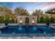 Backyard pool with a decorative stone wall, water feature, and lush landscaping at 11385 N Luckenbach St, Surprise, AZ 85388
