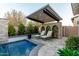 Outdoor lounge space with chaise lounges, overhead canopy, and stone accents near the pool at 11385 N Luckenbach St, Surprise, AZ 85388
