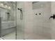 Modern walk-in shower with tile surround, a bench, and shower head with handheld sprayer at 11385 N Luckenbach St, Surprise, AZ 85388