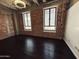 Spacious bedroom features exposed brick walls, high ceilings, hardwood floors and natural light from large windows at 114 W Adams St # 302, Phoenix, AZ 85003