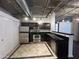 Modern kitchen features stainless steel appliances, dark cabinetry, stone countertops, and tiled flooring at 114 W Adams St # 302, Phoenix, AZ 85003