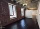 Bright living room with hardwood floors, exposed brick, and industrial-style lighting at 114 W Adams St # 302, Phoenix, AZ 85003