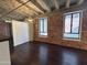 Inviting living area with exposed brick, concrete ceiling, hardwood floors, and industrial-style lighting at 114 W Adams St # 302, Phoenix, AZ 85003