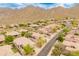 Expansive aerial shot of a desert community nestled amongst rolling hills, revealing lush landscaping at 11490 E Beck Ln, Scottsdale, AZ 85255