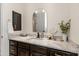 Modern bathroom vanity featuring a granite countertop, dark wood cabinets, and modern mirror at 11490 E Beck Ln, Scottsdale, AZ 85255