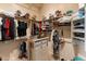 Bright walk-in closet with custom shelving for optimal storage of clothes, shoes, and hats at 11490 E Beck Ln, Scottsdale, AZ 85255