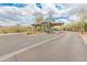 Elegant entry gate with stone pillars and desert landscaping, offering security and natural beauty at 11490 E Beck Ln, Scottsdale, AZ 85255