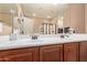 Bathroom featuring double sinks, wood cabinetry, and a large mirror for added convenience at 12226 W Planada Ln, Sun City, AZ 85373