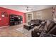Comfortable living room features a red accent wall, stylish furniture, and tile floors at 12226 W Planada Ln, Sun City, AZ 85373