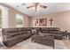 Spacious living room features a large sectional couch, ceiling fan and stylish decor at 12226 W Planada Ln, Sun City, AZ 85373
