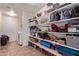 This storage room includes rows of shelving with household items, laundry machines, and tiled floor at 12226 W Planada Ln, Sun City, AZ 85373