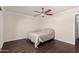 This bedroom features a ceiling fan, dark wood floors, and neutral-colored walls at 12241 N 49Th Ave, Glendale, AZ 85304