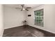 Bright bedroom with hardwood floors, fan, and a window overlooking the exterior at 12241 N 49Th Ave, Glendale, AZ 85304