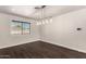 Eat-in kitchen and dining area featuring wood floors, modern light fixture, and window with blinds at 12241 N 49Th Ave, Glendale, AZ 85304