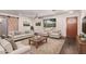 Bright living room is furnished with a neutral sofa, chairs, and area rug over dark hardwood floors at 12241 N 49Th Ave, Glendale, AZ 85304