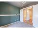 A carpeted bedroom with green walls featuring a view of a bathroom with hardwood flooring at 12613 N 51St Dr, Glendale, AZ 85304