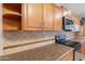 Kitchen showcasing oak cabinets, granite-style countertops, stainless steel appliances, and an attractive tile backsplash at 12613 N 51St Dr, Glendale, AZ 85304