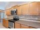 Kitchen featuring oak cabinets, laminate countertops, stainless steel appliances, and tile backsplash for a classic design at 12613 N 51St Dr, Glendale, AZ 85304