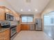 Functional kitchen featuring wood cabinets, stainless steel appliances, laminate countertops, and neutral tile floors at 12613 N 51St Dr, Glendale, AZ 85304