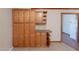 Kitchen pantry with maple cabinetry, granite counters and curved shelving beside an open doorframe at 12613 N 51St Dr, Glendale, AZ 85304