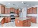 Kitchen with a large island, stainless steel appliances, granite countertops, and warm, wood cabinets at 1383 E Prescott Pl, Chandler, AZ 85249