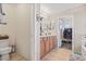 Bright bathroom with double vanity, tile floors, and a walk-in closet filled with clothing at 15241 W Madison St, Goodyear, AZ 85338