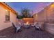 Backyard fire pit surrounded by comfortable seating and decorative string lights at 15488 W Aster Dr, Surprise, AZ 85379
