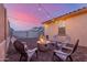 Backyard fire pit with gravel surround, seating, and inviting string lights for evening enjoyment at 15488 W Aster Dr, Surprise, AZ 85379