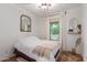 Cozy bedroom with white walls, wood floors, and natural light from a window at 15488 W Aster Dr, Surprise, AZ 85379
