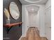 Modern entryway with wood floors, a decorative mirror, and access to the home's interior at 15488 W Aster Dr, Surprise, AZ 85379