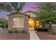 Charming single-story home with stone accents, a covered porch, and manicured landscaping at 15488 W Aster Dr, Surprise, AZ 85379