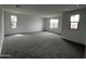 Large, open bedroom area with carpeted floors, neutral paint, and natural light at 17481 W Fulton St, Goodyear, AZ 85338